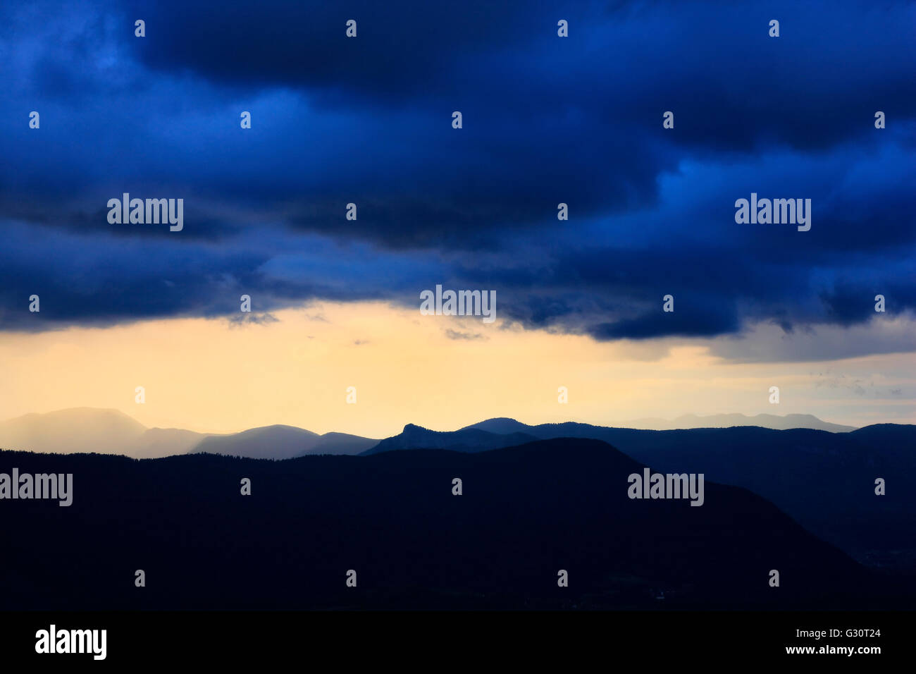 Gewitterhimmel über Hügel vor Sonnenuntergang Stockfoto