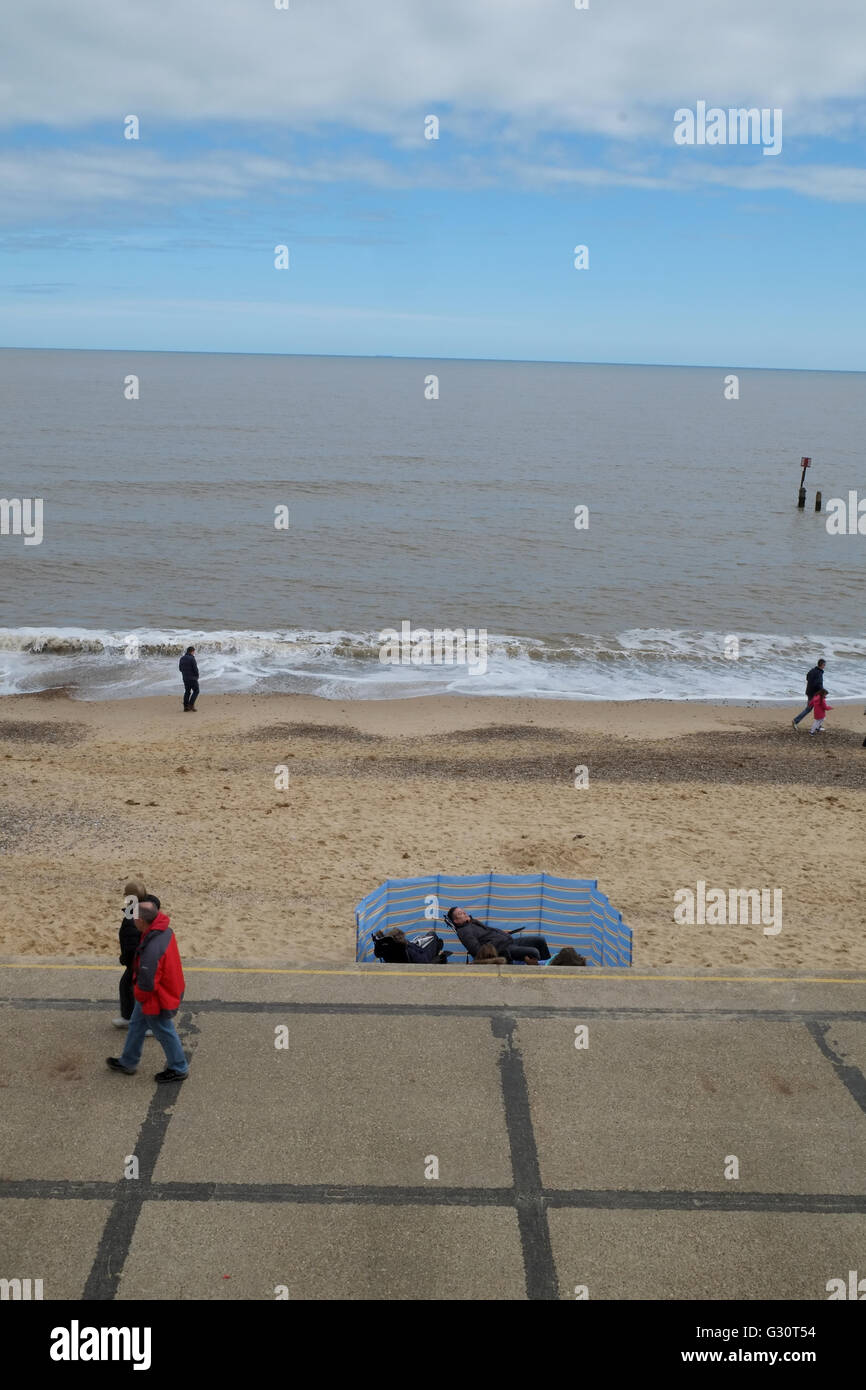 Humorvolle lustige Winter am Meer Szene zeigt Menschen zu Fuß und versteckt sich vor der Kälte Stockfoto