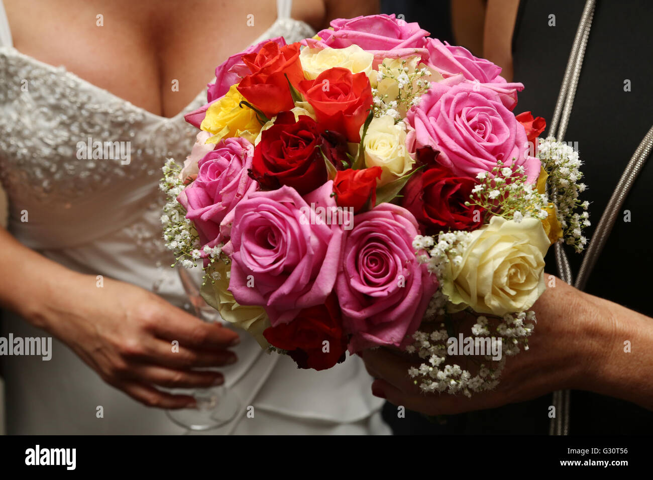 Hochzeitsszene mit ein Detail der Bräute Bouquet von Blumen, die rosa Rosen und roten Rosen enthält Stockfoto