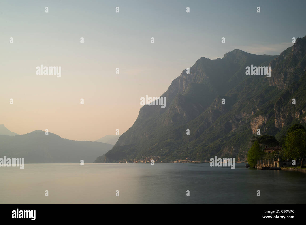 Steile und schroffe Berghänge und Felsen am See in der Nähe von Marone am Lago d ' Iseo in warmes Sonnenlicht bei Sonnenuntergang, Lombardei, Italien Stockfoto