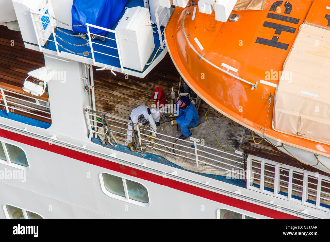 Crew-Mitglieder Schweißen einen Reparatur-Patch auf einem Kreuzfahrtschiff, während Touristen an Land sind.  Costa Maya, Mexiko Stockfoto