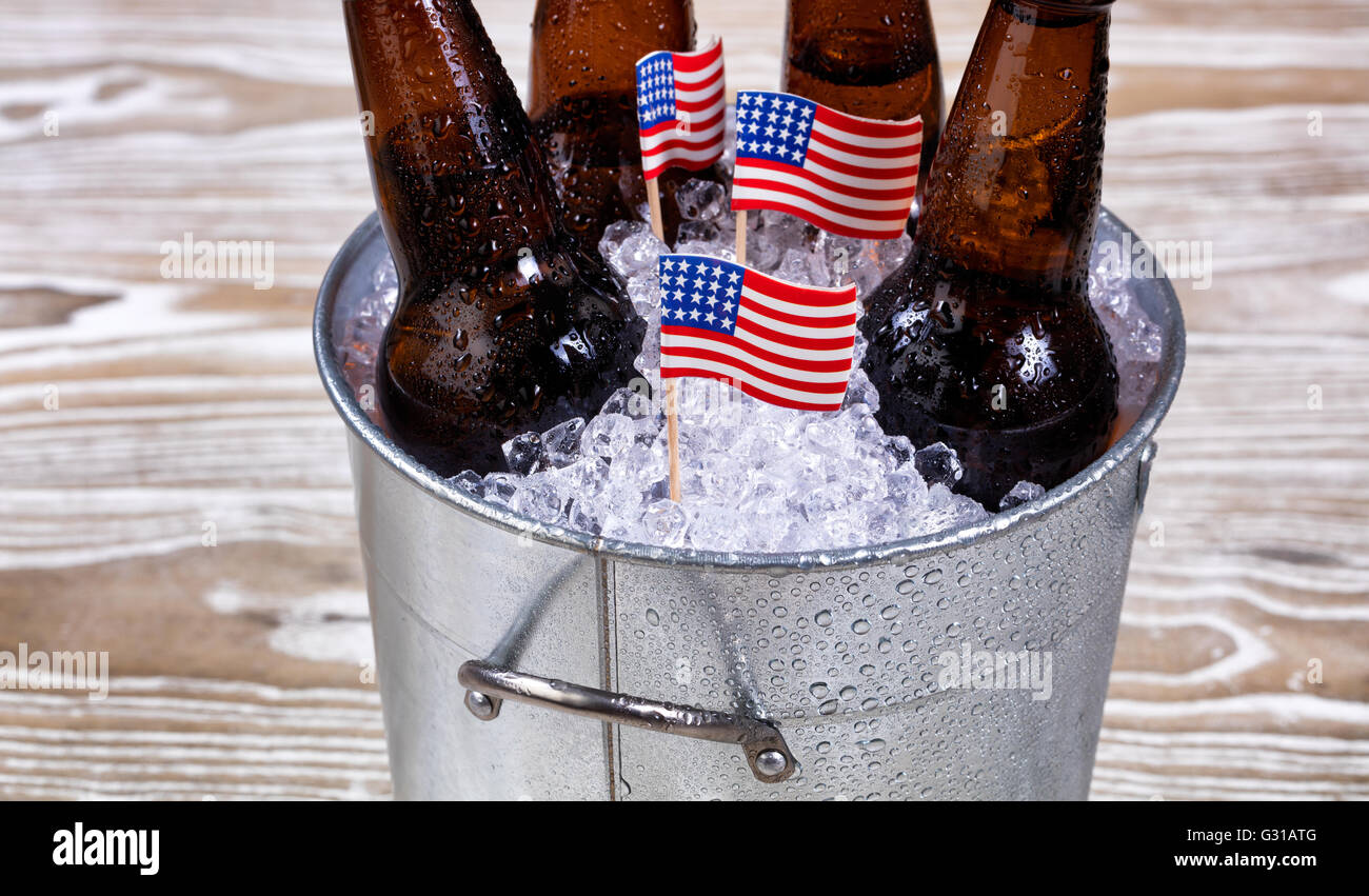 Miniatur-USA-Flaggen in Eimer mit Eis mit Flaschenbier. Fourth Of July Ferienkonzept für Vereinigte Staaten von Amerika. Stockfoto