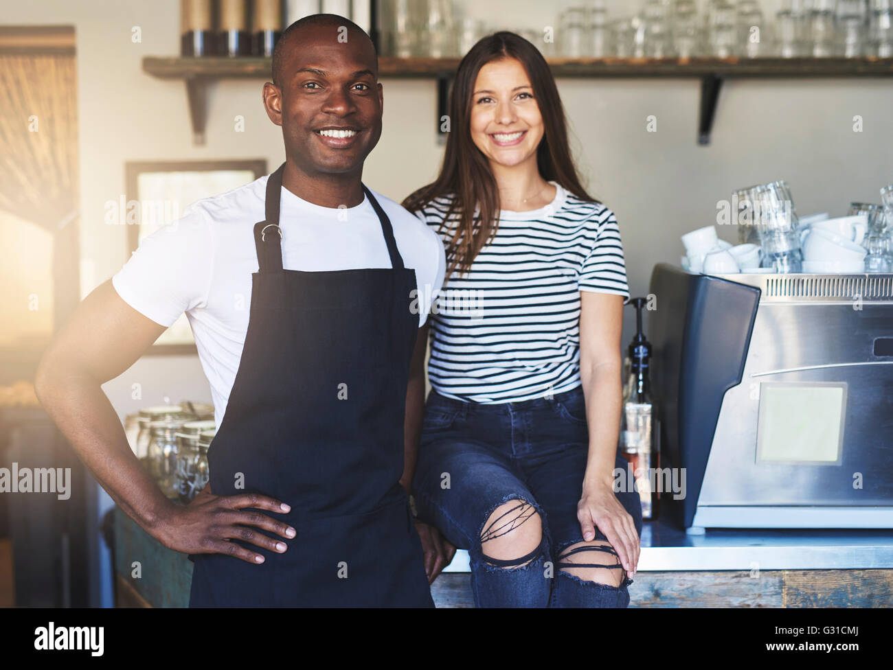 Paar glückliche Afrikas und des kaukasischen junge Arbeiter zusammen im Restaurant am Tisch stehen Stockfoto