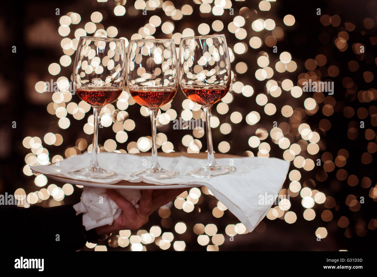 Weinglas gegen Lichter Weihnachtsdekoration Stockfoto