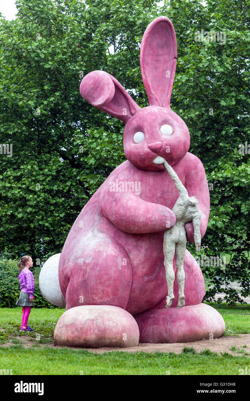 Plzen Tschechische Stadt Pilsen Tschechische Republik zeitgenössische Kunst Statue rosa Kaninchen, Mädchen, das die Kunstwerke im Freien betrachtet, Kaninchen essen Menschen, Tierkunst Stockfoto