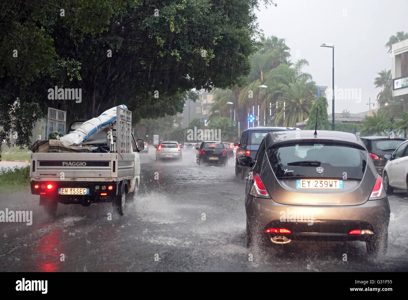 Aci Trezza, Italien, Autos fahren auf einer überfluteten durch Regenwasser Street Stockfoto