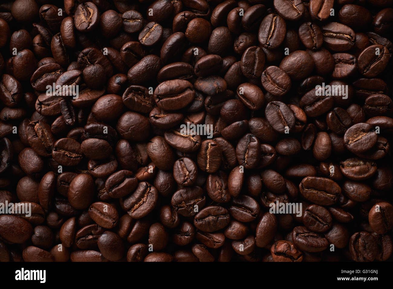Lebensmittelzutaten: dunkel geröstete Kaffeebohnen als flachen Hintergrund angeordnet Stockfoto