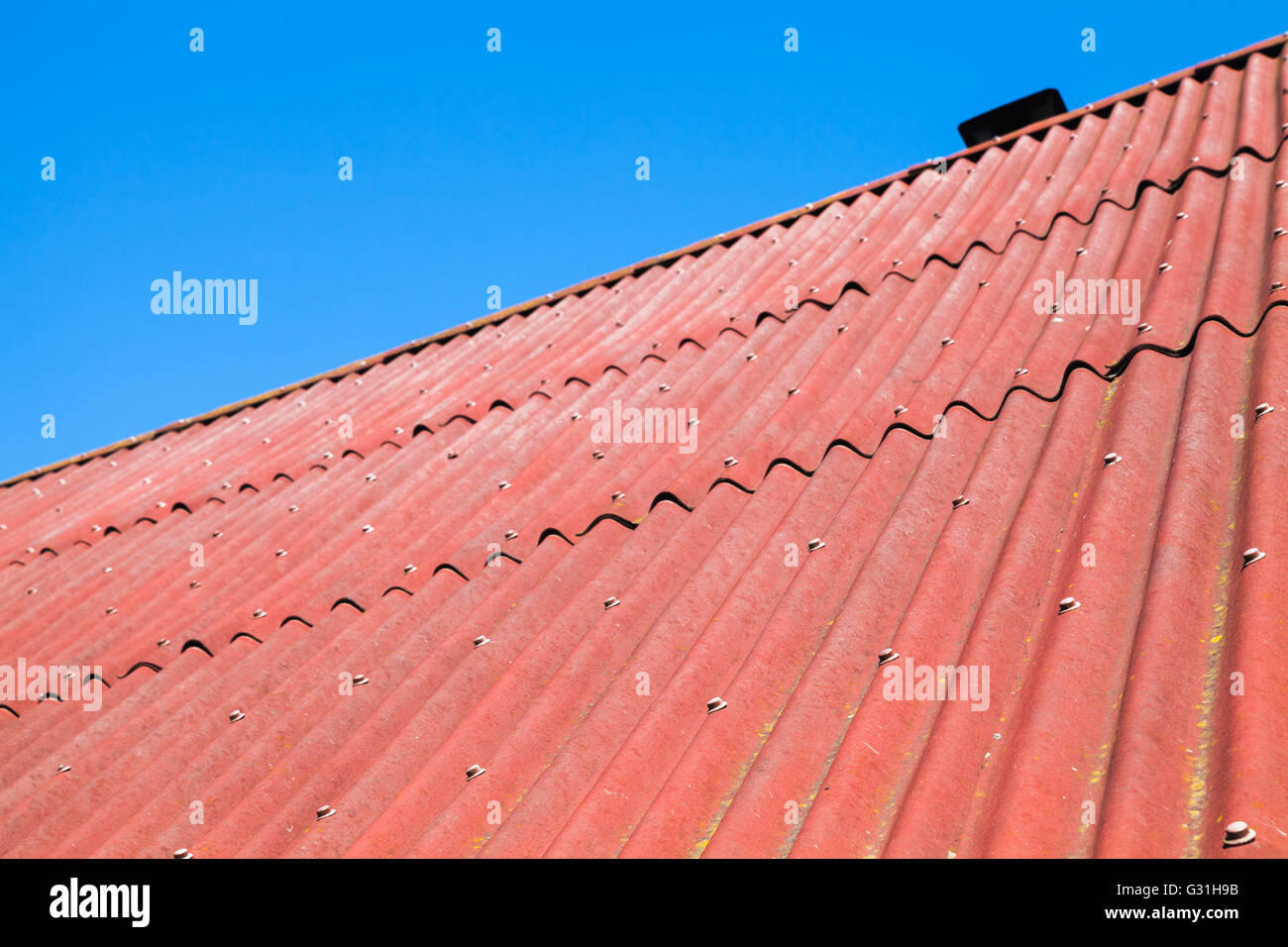 Blauer Himmel und rotem Dach gemacht von Wellpappe Karton bituminöse, Foto Hintergrundtextur Stockfoto