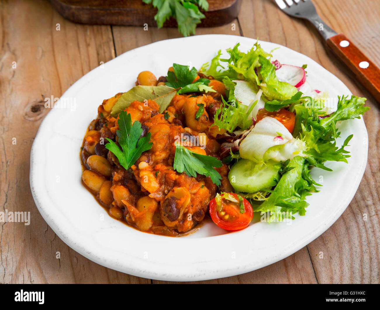 Bohneneintopf mit frischer Petersilie und Gemüse Salat Stockfoto