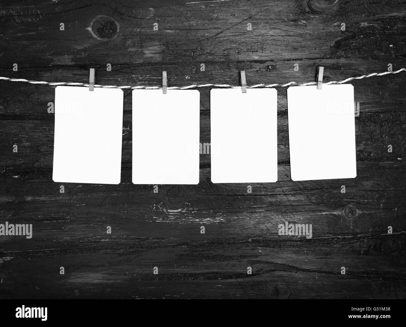 Leeres Papier oder Foto Rahmen rot gestreiften Wäscheleine hängen. Hölzerne Hintergrund. Vorlage für Ihren Text. Stockfoto