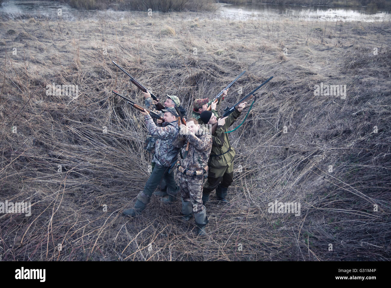 Gruppe von Jägern stehen Rücken an Rücken im ländlichen Bereich und mit dem Ziel und bereit sind, eine Aufnahme zu machen. Konzept für die Teamarbeit Stockfoto