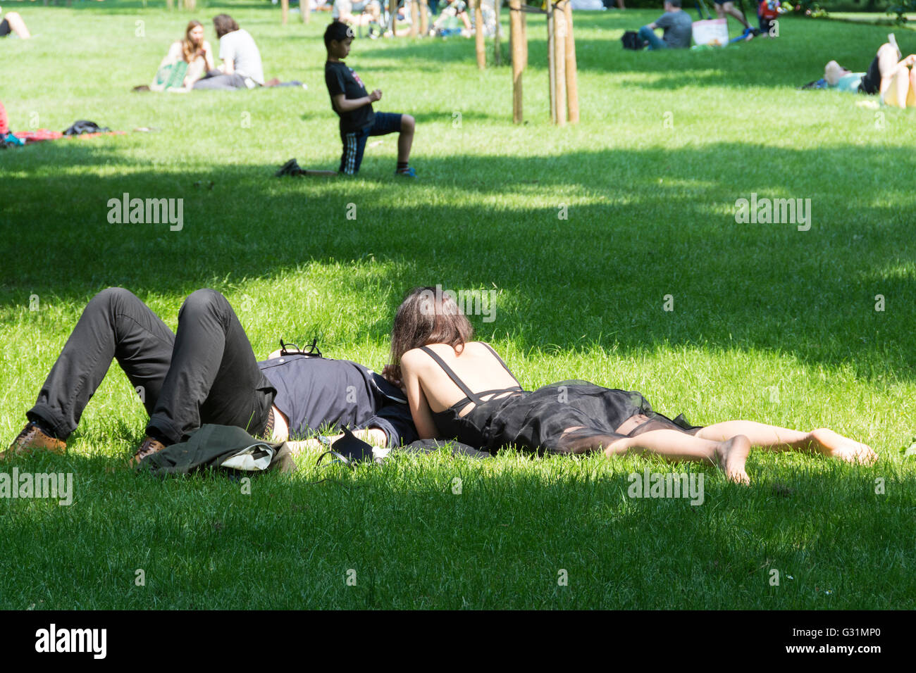 Ein Paar, das sich im Hyde Park, City of Westminster, London, England, Großbritannien sonnt Stockfoto