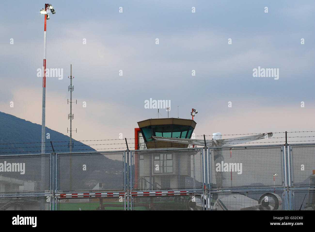 Kleinen internationalen Flughafen mit Düsenflugzeug, Kontrollturm, Barb Wire Schutzzaun und Beleuchtungsanlagen Stockfoto