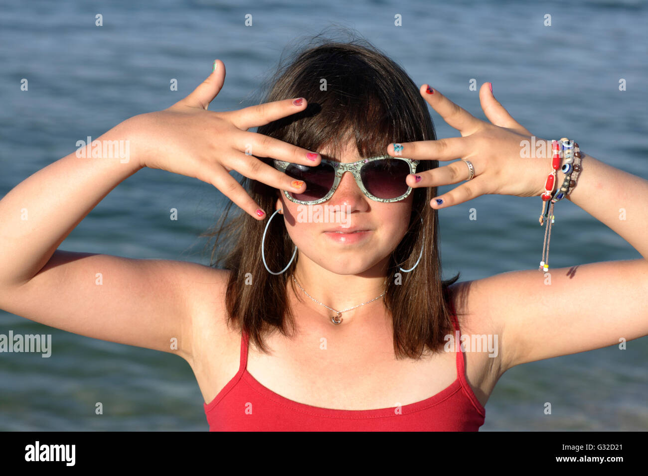 Mädchen, 12, Sonnenbrille und zeigen ihre bunt lackierten Fingernägel Stockfoto