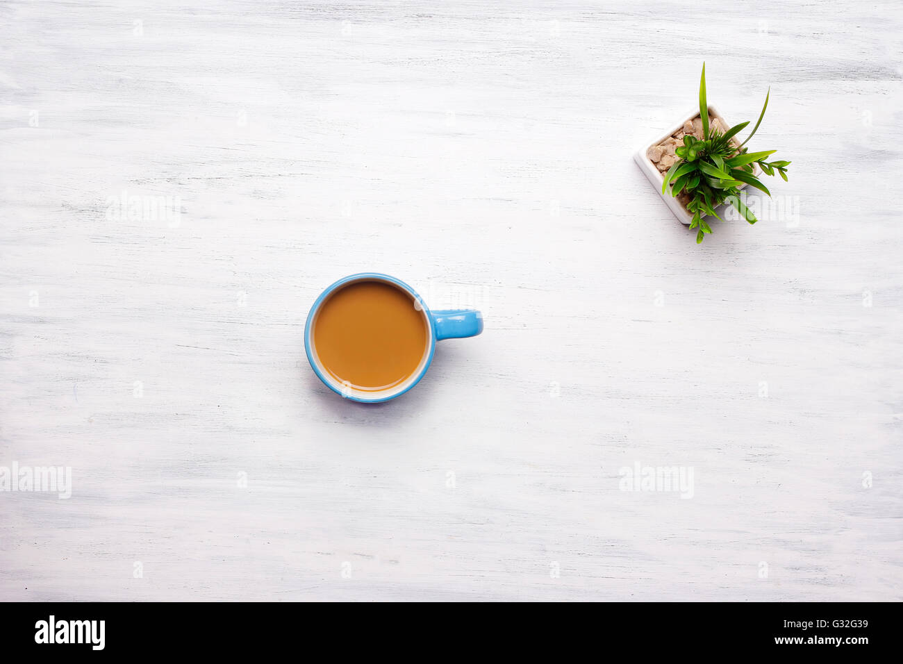 Draufsicht der Tasse Kaffee auf einem weißen Holztisch. Pause von der Arbeit, Lifestyle-Konzept. Stockfoto