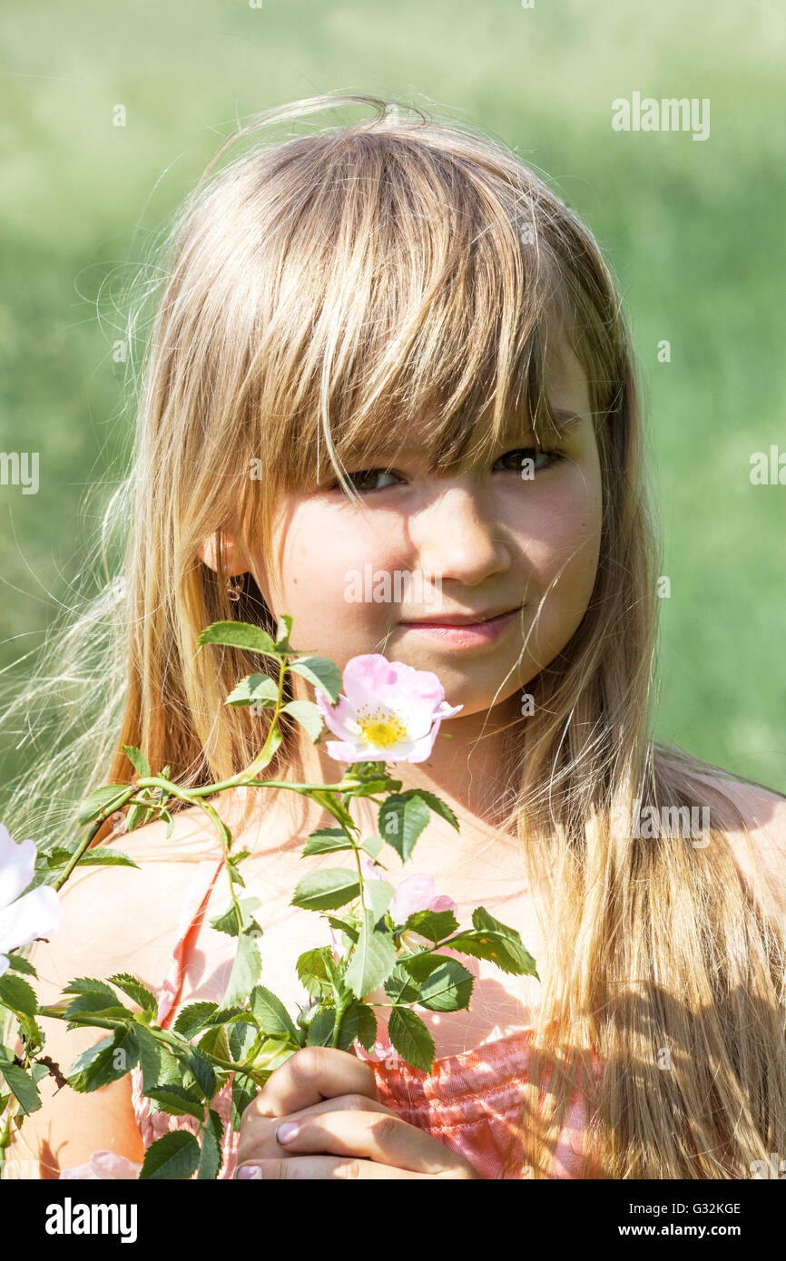 6 - 7 Jahre altes Mädchen mit Blume von wilde rosa Stockfoto