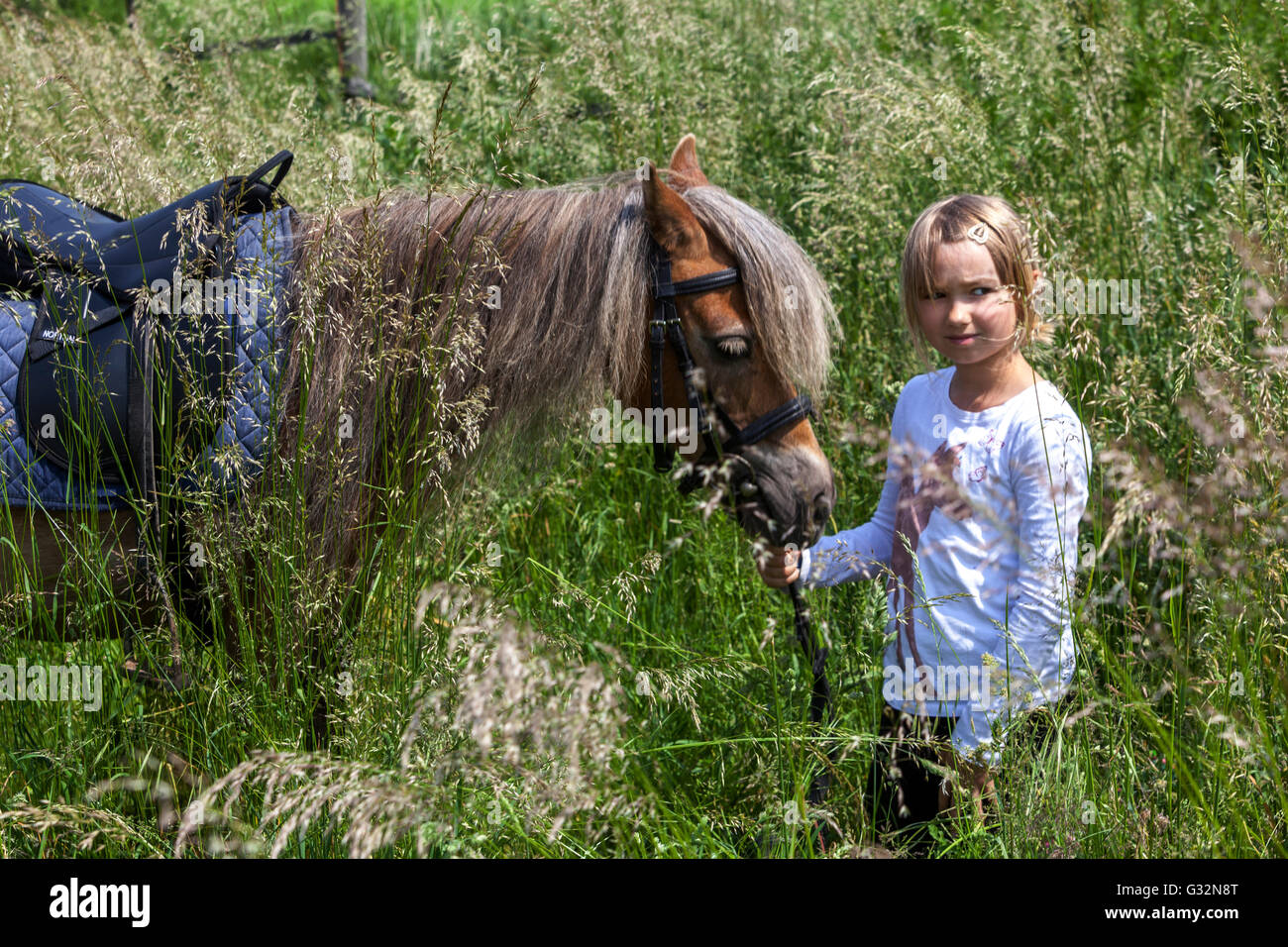 Kleines Mädchen Ponyweide, die mit einem Pferd läuft Stockfoto