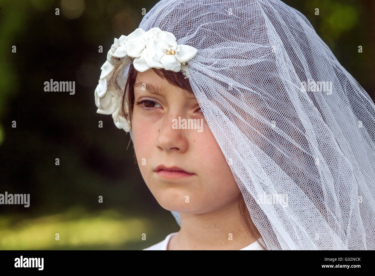 Alter der Unschuld 6-7 Jahre altes Mädchen Weiße Braut Schleier Spiel Kindergesicht trauriger Ausdruck trauriges Mädchen außerhalb Kind weibliche Kleidung Preteen Gefühl Gesicht Stockfoto