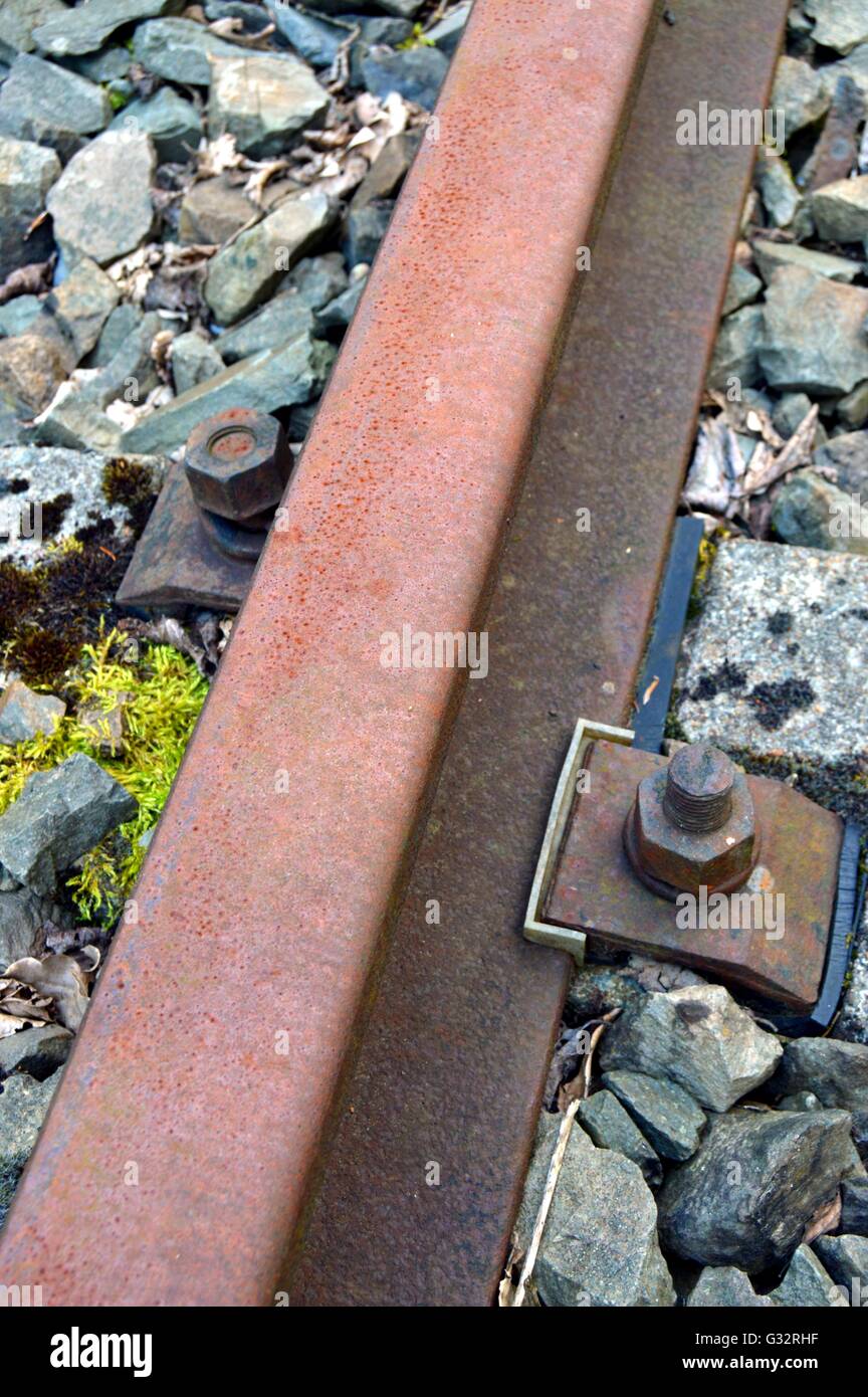 Fixierung der Schiene der Eisenbahn mit Nüssen. Und isolierende Gummisohle und Nylon. Stockfoto