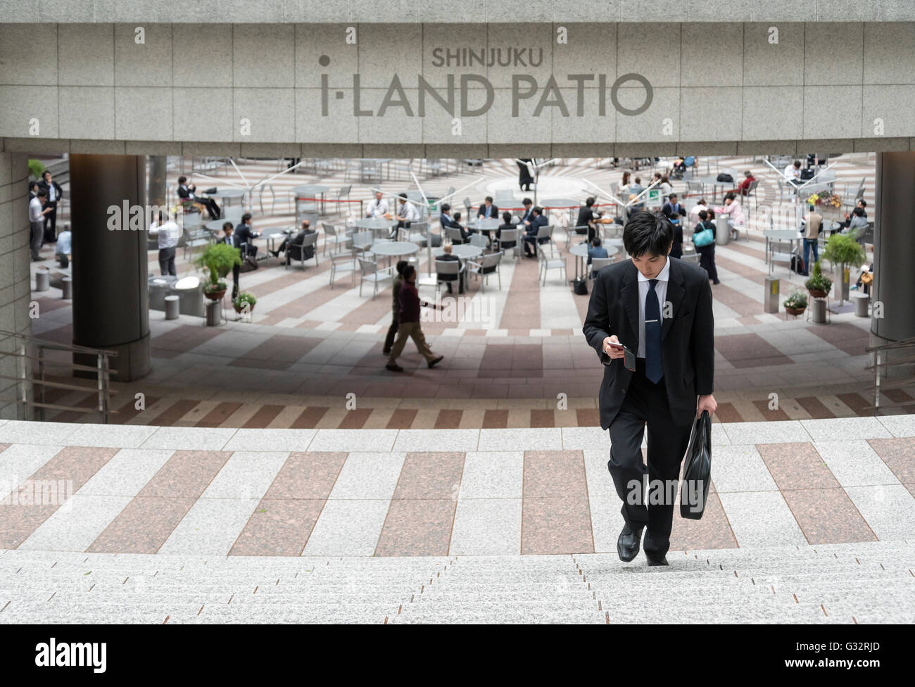 Japanischer Geschäftsmann durchläuft-Land Gebäude Patio, Shinjuku, Tokio, Japan Stockfoto