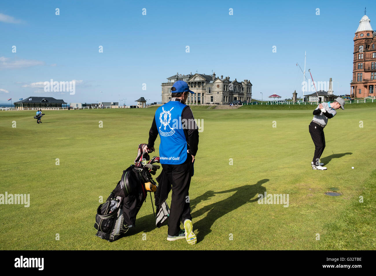 Golfer mit Caddie spielen zum 18. Grün auf Old Course in St. Andrews in Fife, Schottland, Vereinigtes Königreich Stockfoto