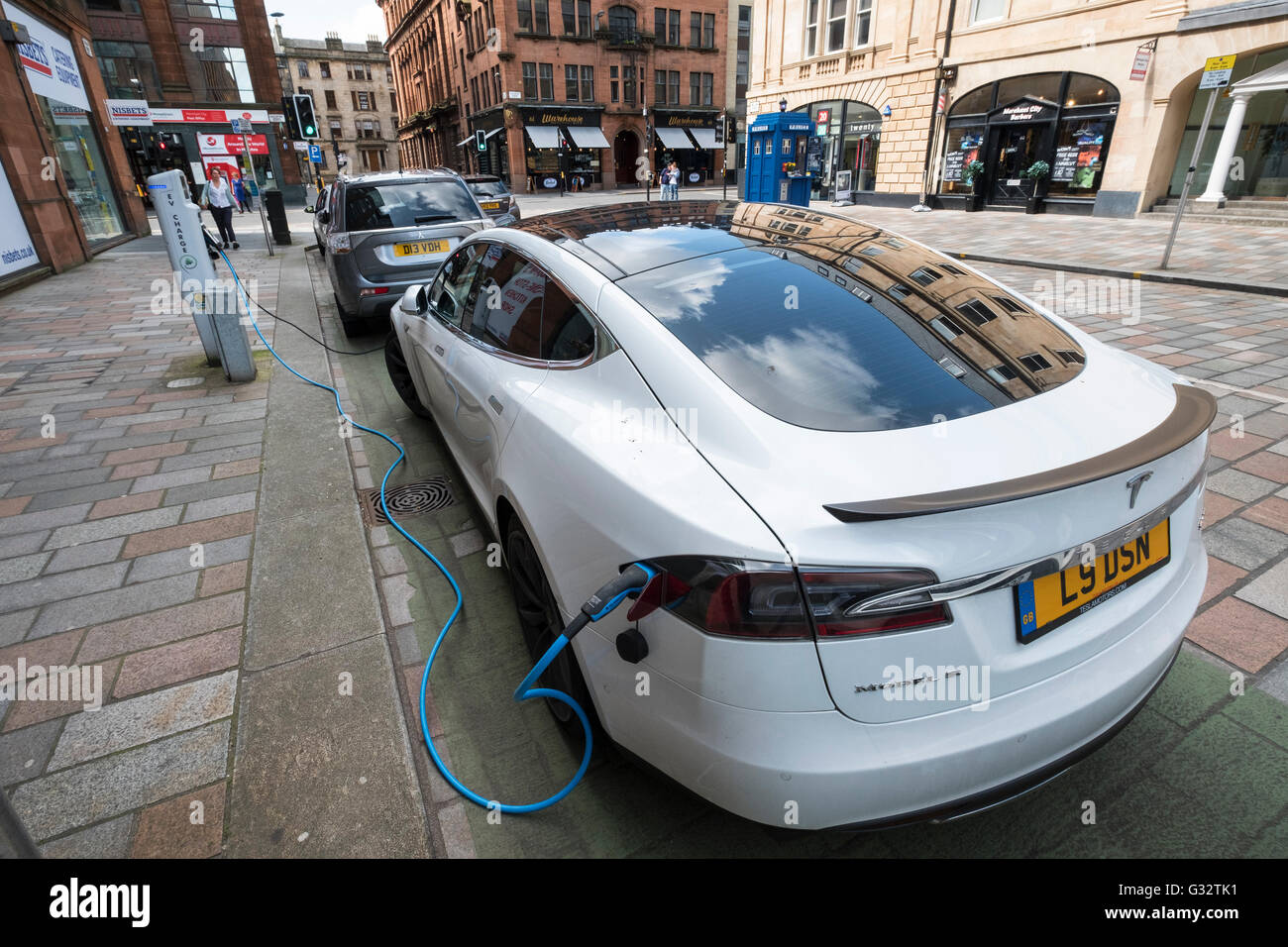 Tesla Elektroauto aufladen in Street im Merchant City in Glasgow, Vereinigtes Königreich Stockfoto