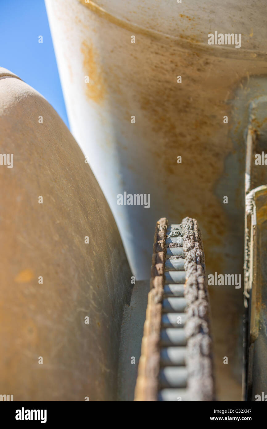 Ausschnitt aus einem alten Betonmischer-LKW, zeigen zwei rostige Metall-Tanks und eine schwere Kette Stockfoto