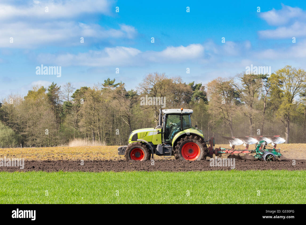 Bauer auf Traktor Pflügen Sandboden im Frühling Stockfoto