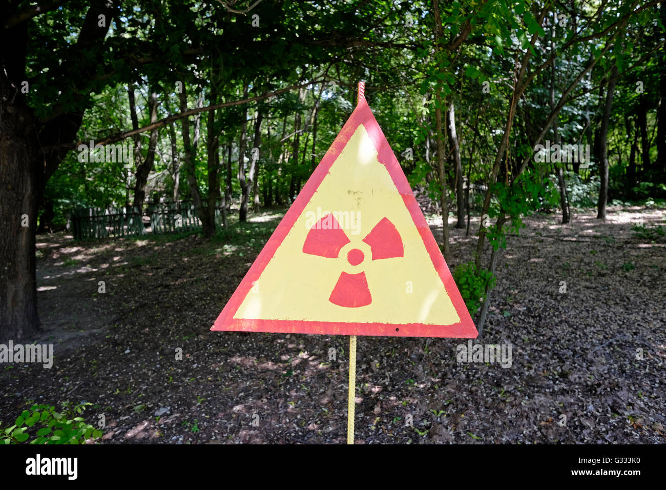 Ein Schild warnt vor der Strahlung am Standort des verlassenen Dorfes Kopachi, das noch radioaktiv ist und am 04. Juni 2016 in der Tschernobyl-Sperrzone in der Ukraine hohe Konzentrationen von Plutonium, Strontium-90 und Cäsium-137 enthält. Der Tschernobyl-Unfall ereignete sich am 26. April 1986 im Kernkraftwerk Tschernobyl in der Stadt Pripyat und war der schlimmste Unfall in der Geschichte, was die Kosten und die Verluste angeht. Stockfoto