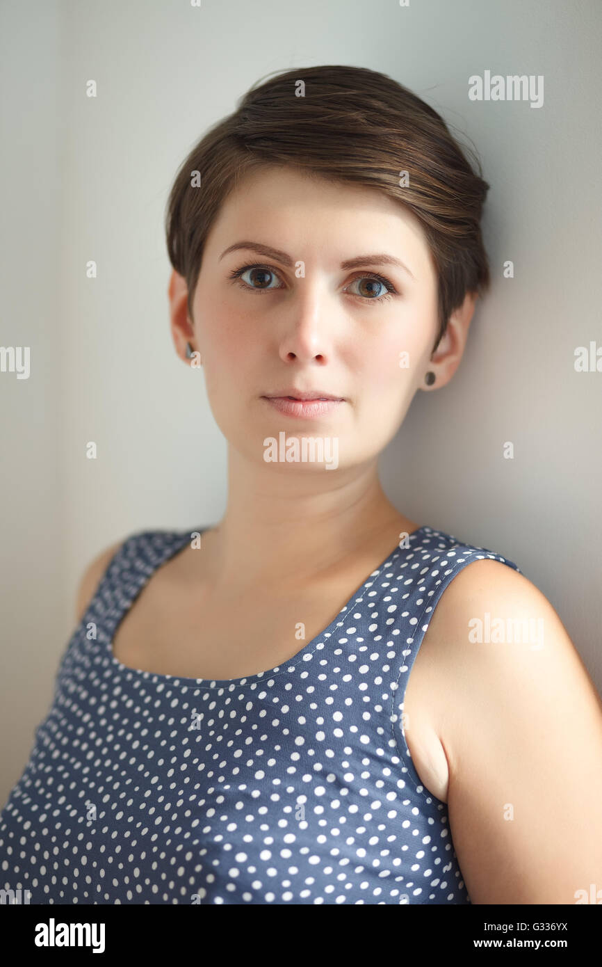 Charmante Kurzhaar junge Frau ohne Make-up auf weißem Hintergrund Stockfoto