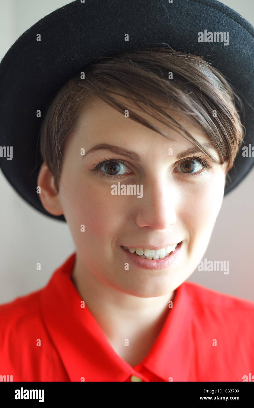 Charmante junge Frau mit Hut ohne Make-up auf weißem Hintergrund Stockfoto