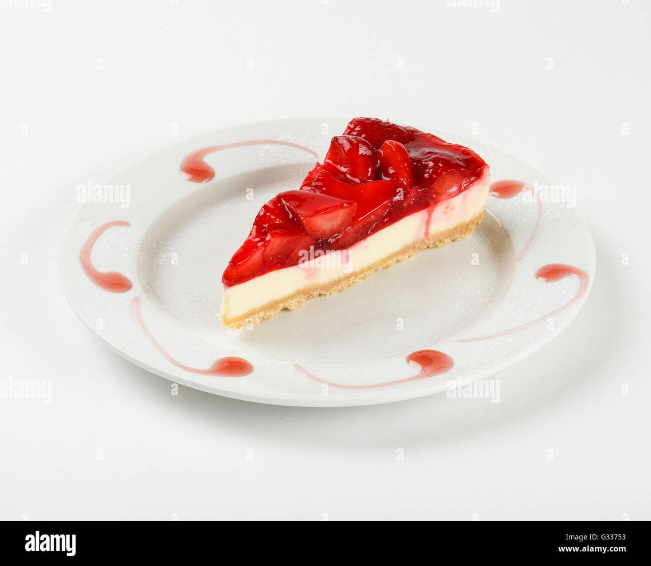 Lecker Käsekuchen mit Erdbeer-Gelee und Marmelade auf dem Teller auf weißem Hintergrund. Schließen Sie die Seitenansicht. Stockfoto