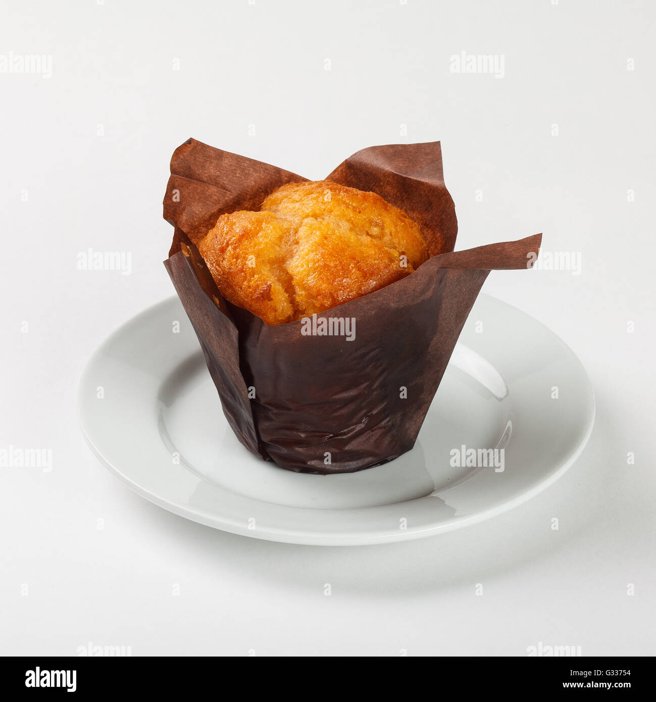 Leckere Muffin Kuchen in braunem Papier auf die Platte auf weißem Hintergrund. Stockfoto