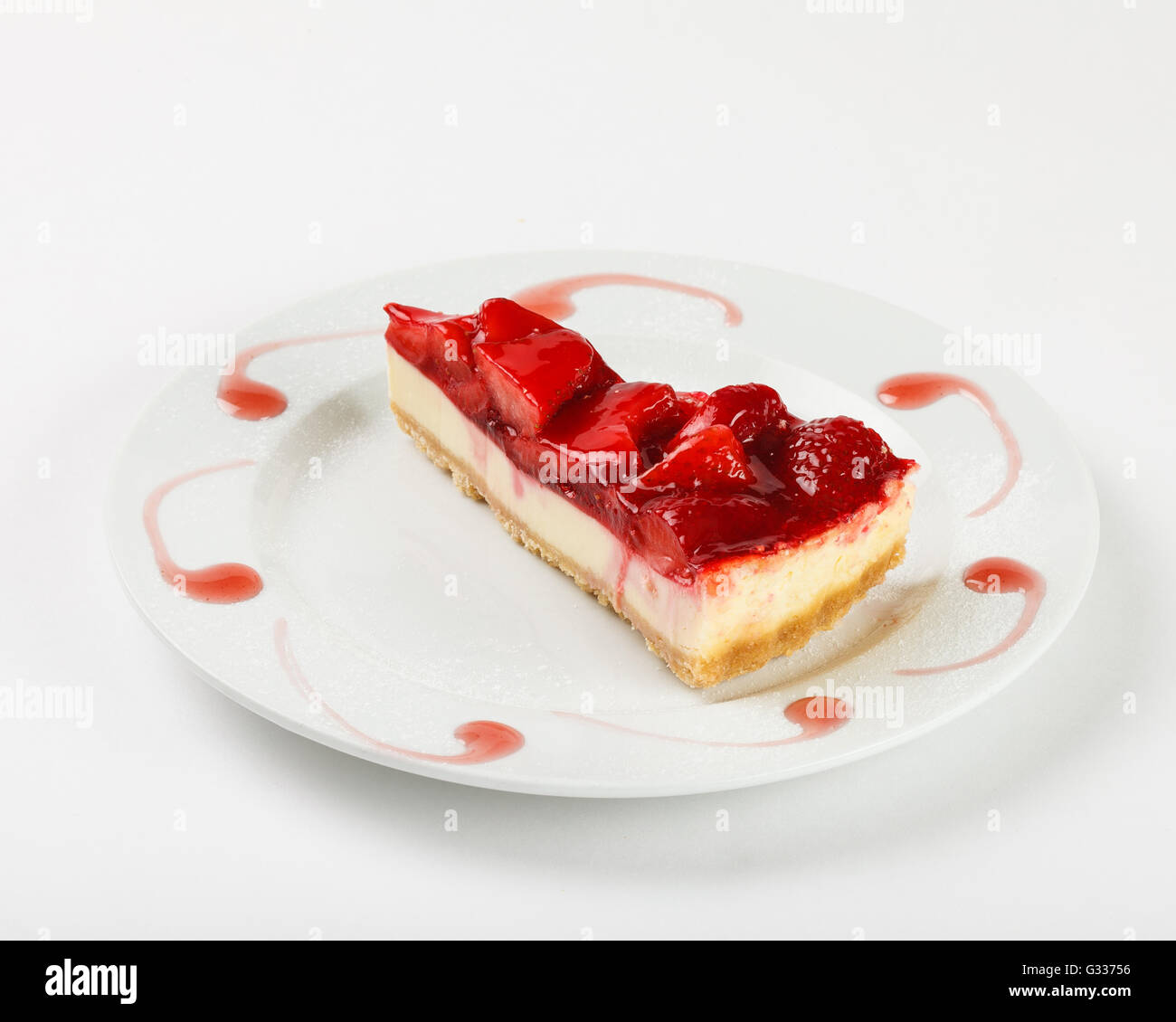 Lecker Käsekuchen mit Erdbeer-Gelee und Marmelade auf dem Teller auf weißem Hintergrund. Schließen Sie die Seitenansicht. Stockfoto