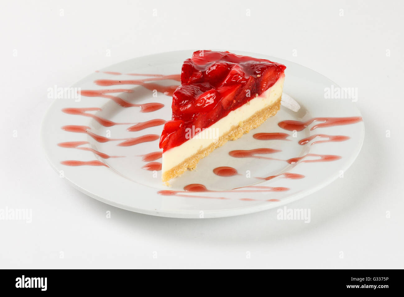 Lecker Käsekuchen mit Erdbeer-Gelee und Marmelade auf dem Teller auf weißem Hintergrund. Schließen Sie die Seitenansicht. Stockfoto