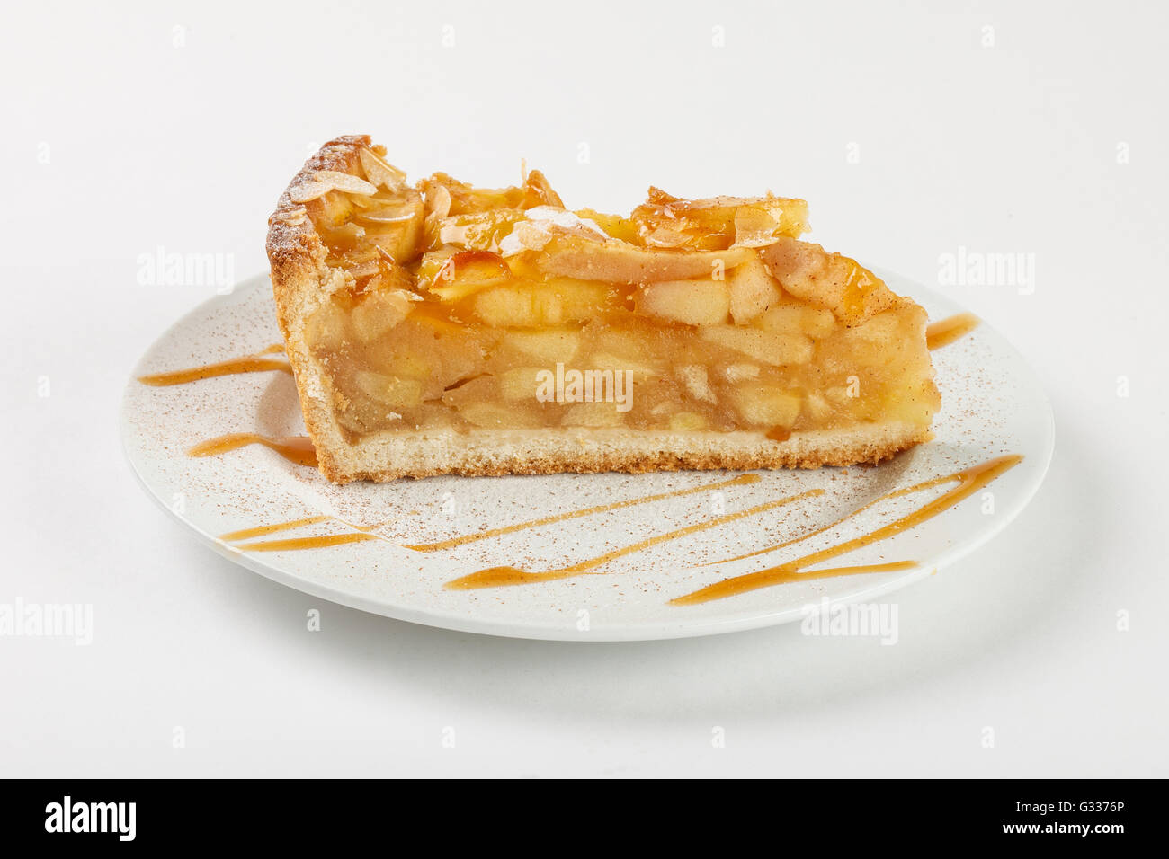 Leckere Apfelkuchen Charlotte mit Karamell auf dem Teller auf weißem Hintergrund. Schließen Sie die Seitenansicht. Stockfoto