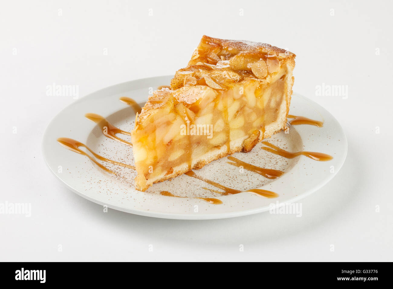 Leckere Apfelkuchen Charlotte mit Karamell auf dem Teller auf weißem Hintergrund. Schließen Sie die Seitenansicht. Stockfoto