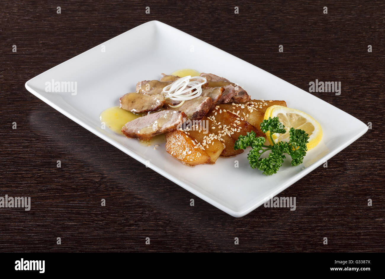 Fleischstücke zartes Kalbfleisch mit Soße, Bratkartoffeln und einer Scheibe Zitrone und Petersilie auf weißen Teller. Europäische Küche. Seite vi Stockfoto