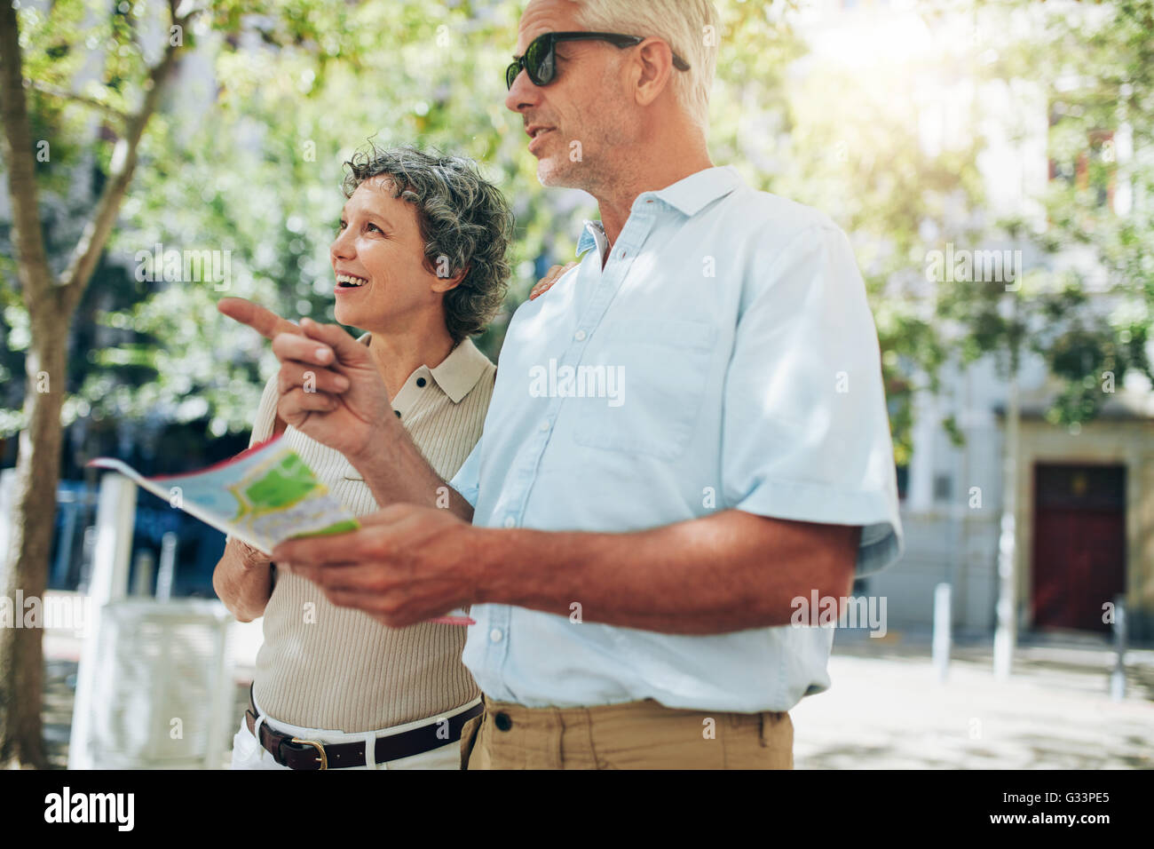 Paar glücklich senior Touristen Kartenlesen. Reifer Mann zeigte auf einen Platz mit Frau bewundern die Aussicht. Stockfoto