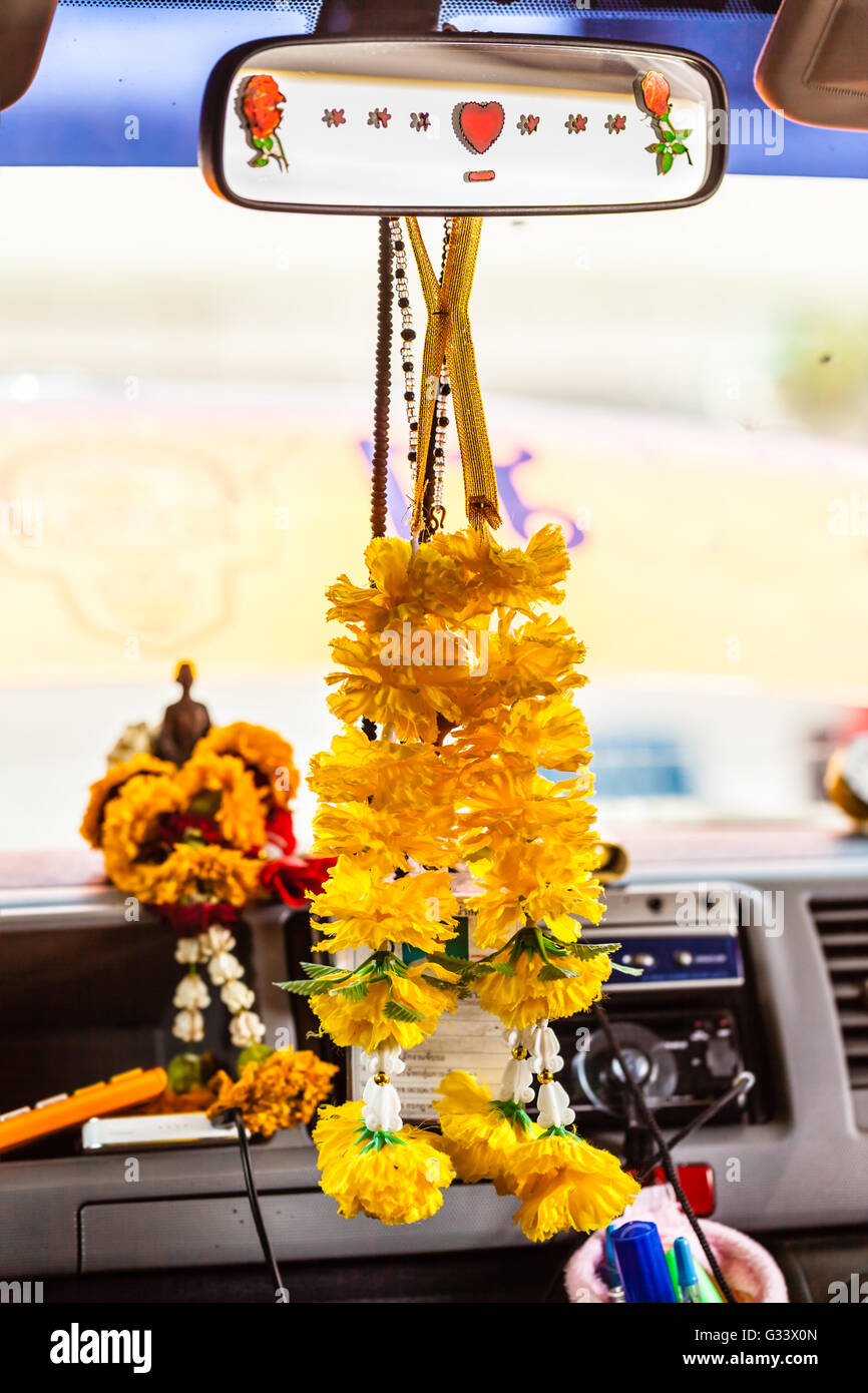 Innenraum eines thailändischen Autos mit den typischen Ringelblume Kranz als Glücksbringer Stockfoto
