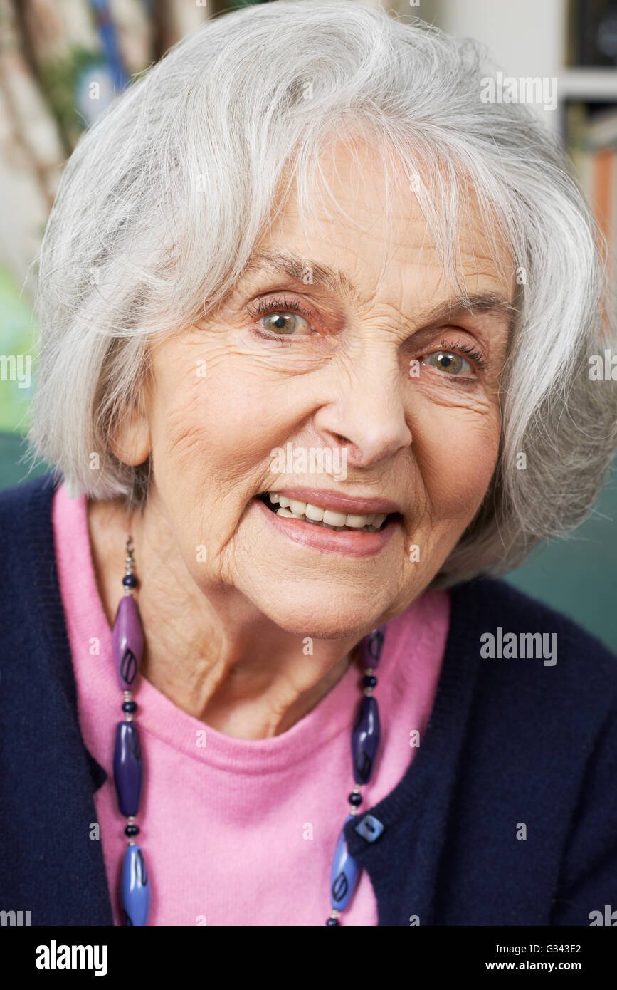 Kopf und Schultern Portrait Of Smiling Senior Frau zu Hause Stockfoto