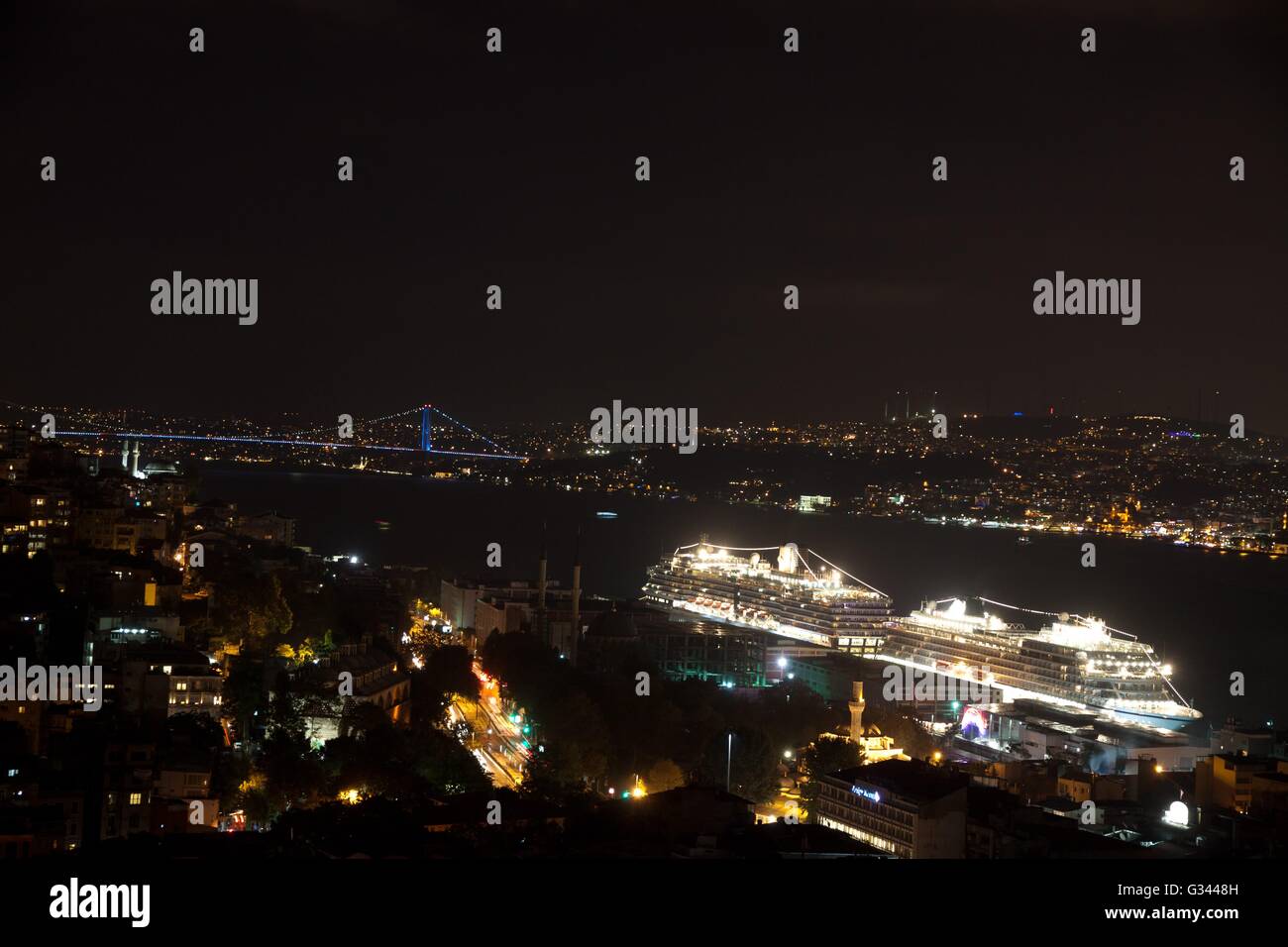 Skyline Istanbuls vom Galata-Brücke bei Nacht mit Kreuzfahrtschiffen, Türkei Stockfoto