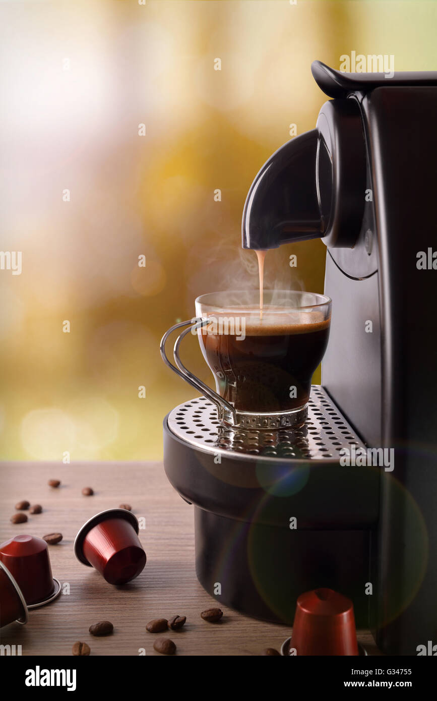 Espresso-Maschine Kaffee mit Kapseln auf Holztisch. Ansicht von vorne. Vertikale Zusammensetzung Stockfoto