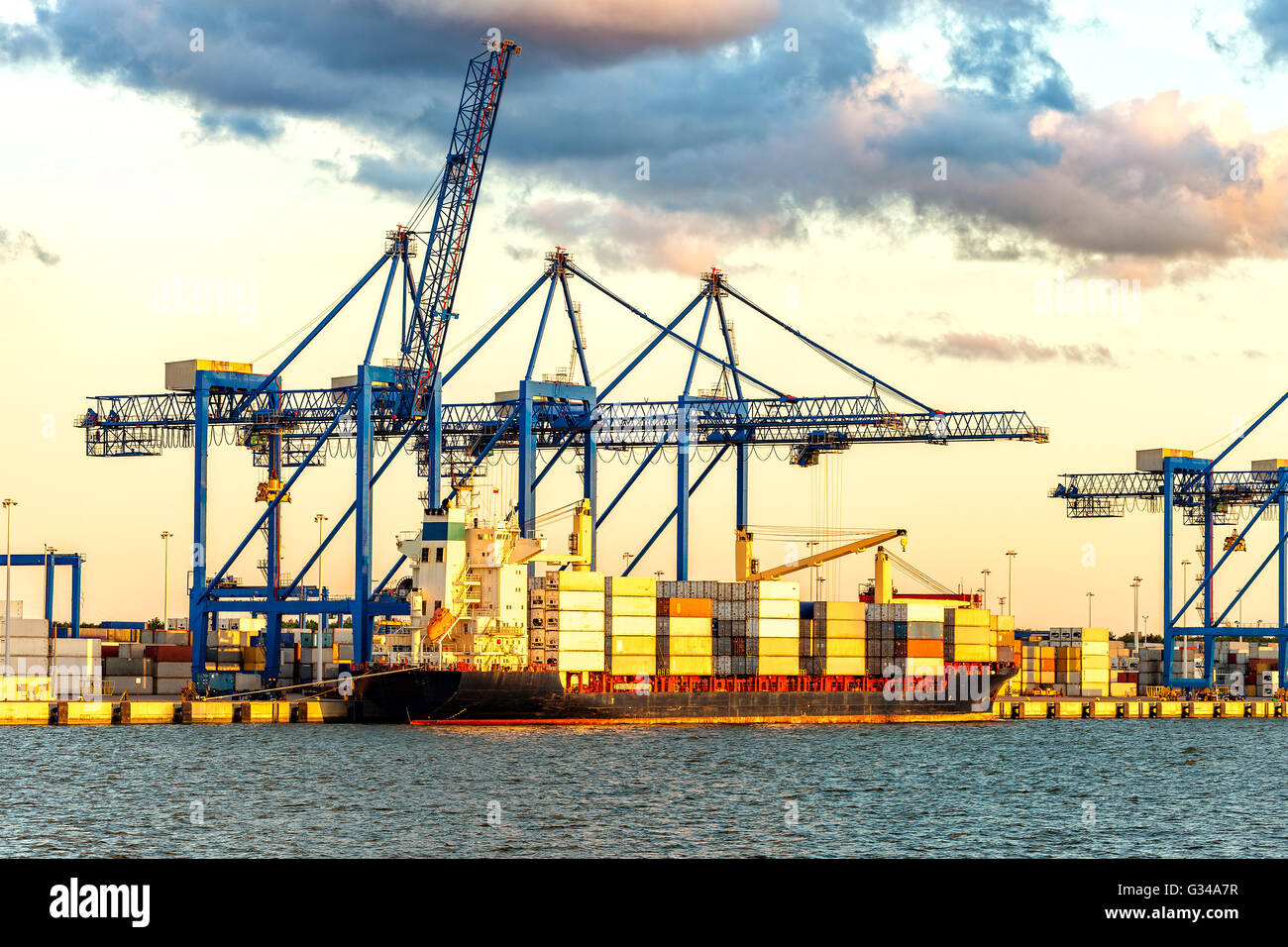 Containerschiff bei Sonnenuntergang im Hafen von Danzig, Polen. Stockfoto