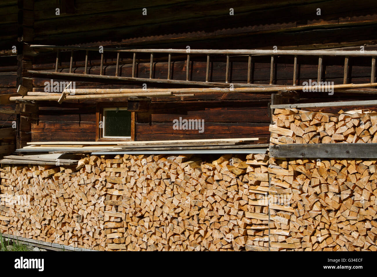 Brennholz gestapelt, indem die Alphütte. Rustikale Landwirtschaft Szene. Stockfoto