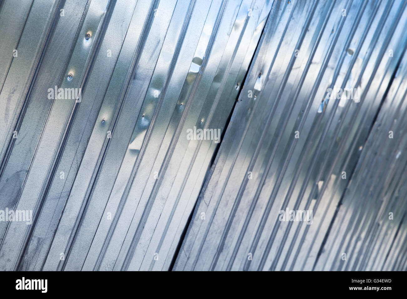 Neue Leuchten aus Wellpappe Metallzaun, industrielle Wand Hintergrundfoto mit selektiven Fokus Stockfoto
