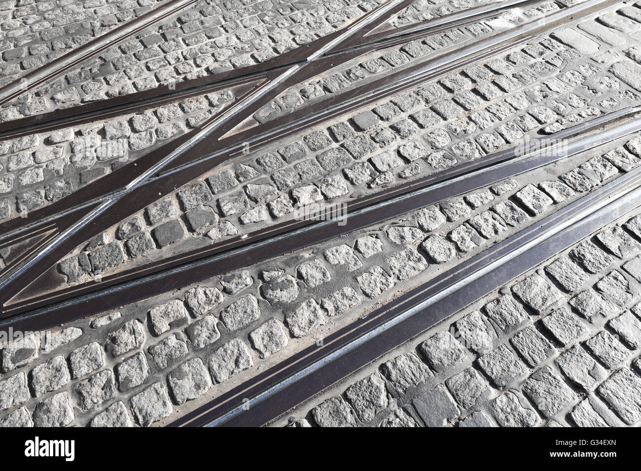 Schnittpunkt der Straßenbahnschienen auf grauem Stein Pflaster Stockfoto