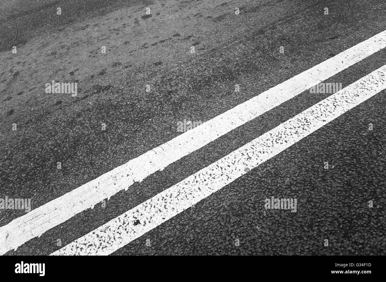 Weiße doppelte Trennlinie über schwarze Autobahn Asphalt, Nahaufnahme Foto mit selektiven Fokus Stockfoto