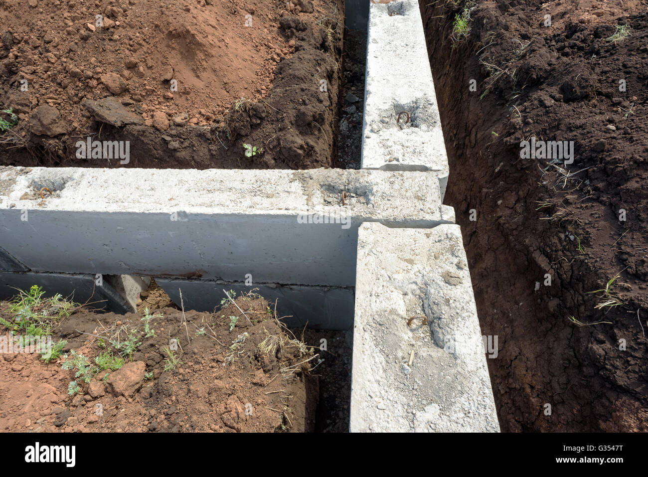 Graue Bau konkrete Bausteine für die Fundamente eines selbst gebauten Hauses verwendet. Aushub und ausgegraben Erde surround Stockfoto