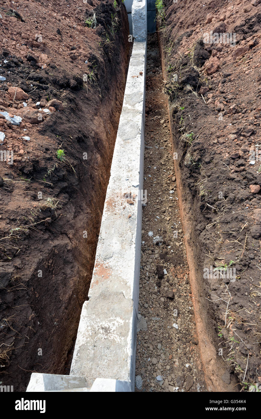 Graue Bau konkrete Bausteine für die Fundamente eines selbst gebauten Hauses verwendet. Aushub und ausgegraben Erde surround Stockfoto